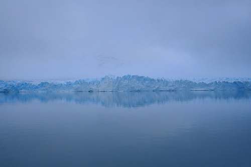 glacier photography of sea near mountain covered with snow cold