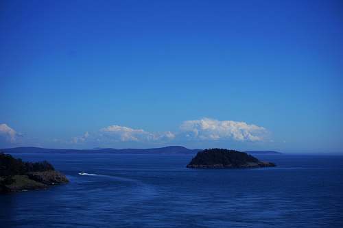 nature speedboat near island during daytime outdoors