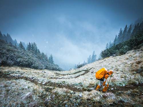blue person walking on mountain during daytime valley