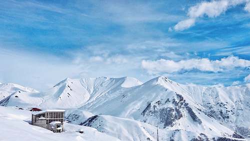 outdoors brown house in the middle of snow field mountain
