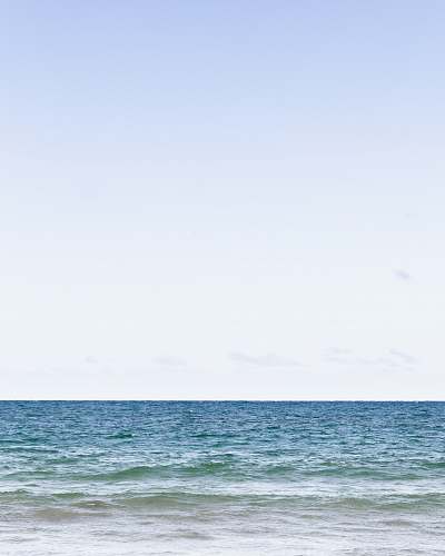 blue calm sea under clear blue sky during daytime ocean