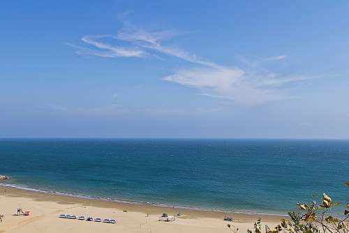 coast aerial photography of body of water and sand beach