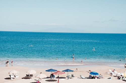 beach people on beach under patio umbrellas coast