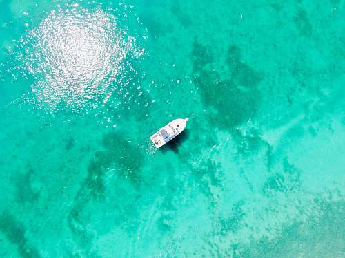 nature aerial photography of white boat in body of water during daytime water