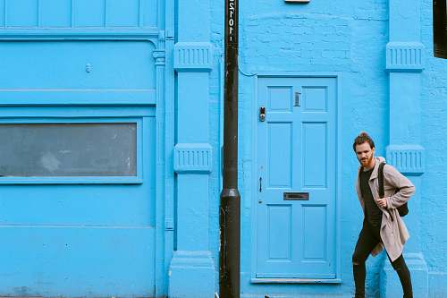 blue man passing through the door during daytime person
