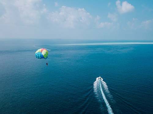 parachute aerial photography of paragliding ocean
