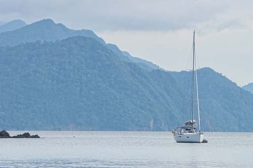 vehicle white sailboat at sea with folded sail vessel