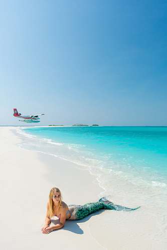 outdoors blonde-haired woman wearing green mermaid costume on seashore sea