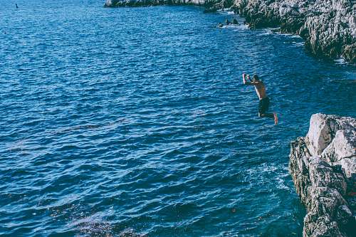 blue person jumped from rock cliff sport