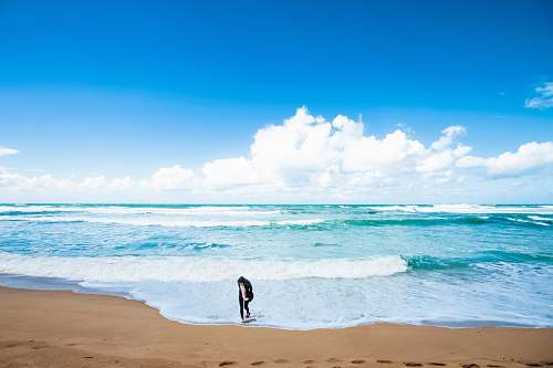 ocean person standing near shore beach