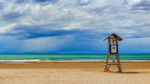 beach photo of lifeguard house on seashore during daytime sea