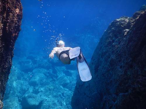 person underwater photo of person wearing flippers diver