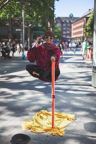accessory man floating holding on orange stick white people watching on the street sunglasses