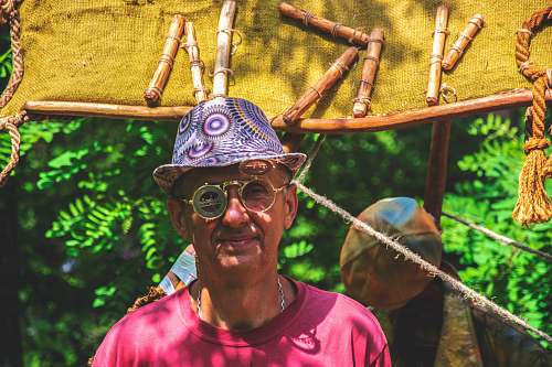 clothing man wearing purple hat near trees and brown signage human
