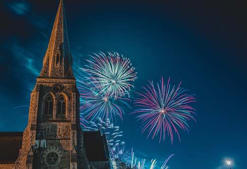 tower photo of pointed-edge church with fireworks architecture