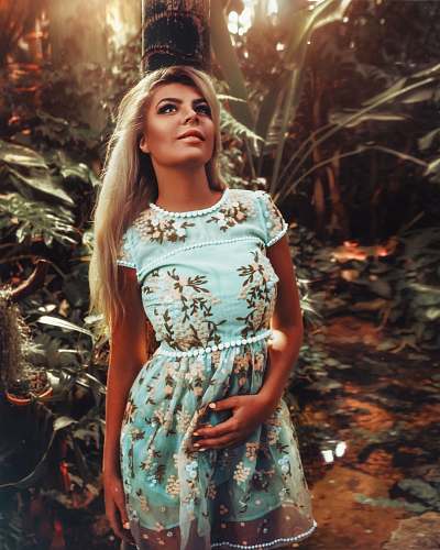 apparel woman standing near trees gown