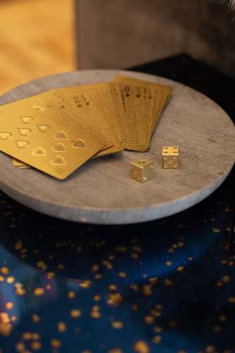 money gold cards and two dices on round wooden platform text
