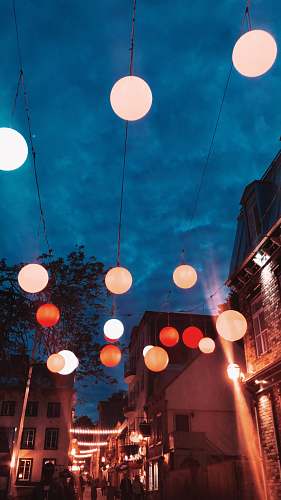 person lighted multicolored lanterns hanging over street lighting