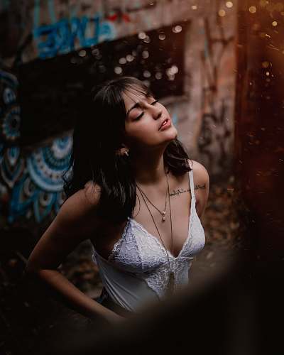 clothing woman in white tank top standing near building person