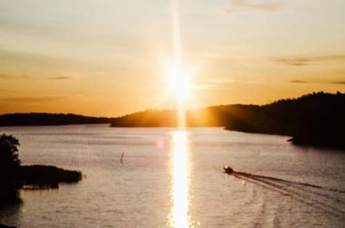 finland boat running on sea during golden hour sun
