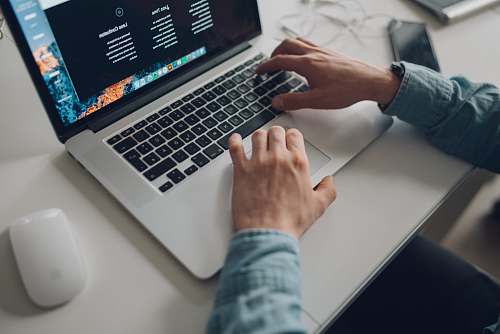 electronics person wearing long-sleeve top working on laptop keyboard