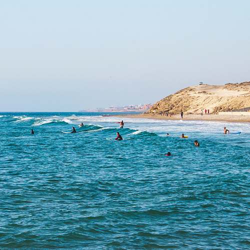 beach people riding surfboards in ocean at daytime water