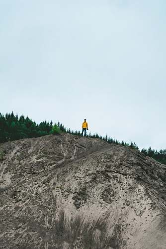 sweden person standing on rock formation near green trees blue