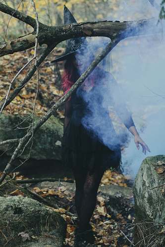 human woman in witch costume standing beside rock person
