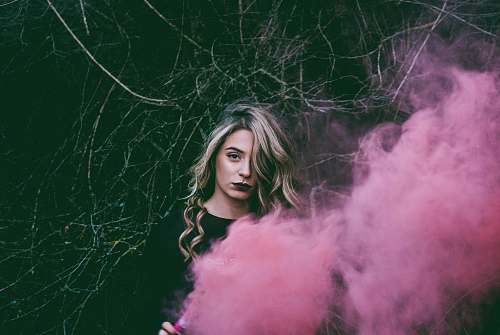 human woman standing near pink smoke person