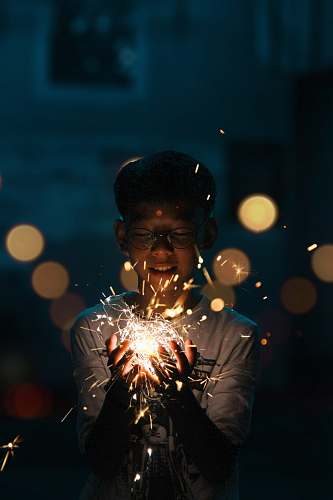 human boy holding lighting crackers lighting
