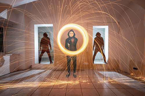 human man holding fire sparks inside room flooring