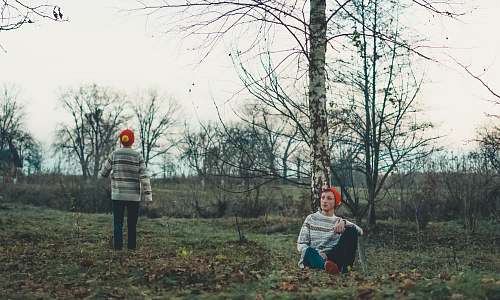 apparel man sitting beside tree clothing