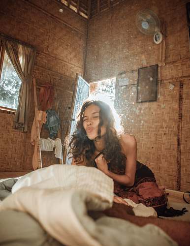 apparel pouting woman wearing brown dress sitting on bed human