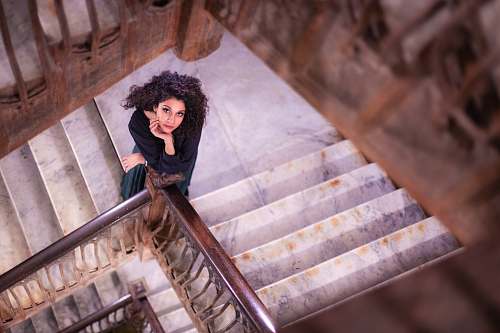 handrail shallow focus photo of woman standing on stairs banister