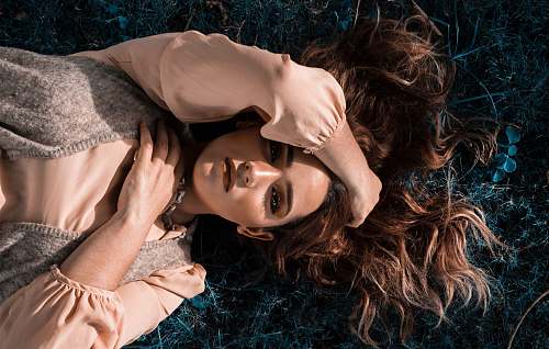 human woman in peach satin dress lying on floor finger