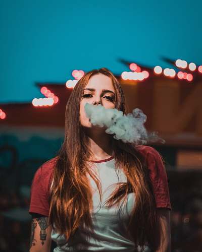 human woman in white and red raglan t-shirt smoking smoke
