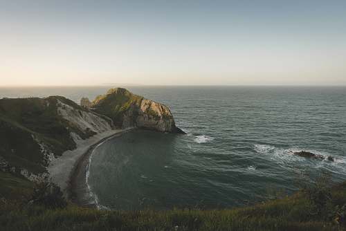 cliff aerial photography of green body of water and mountain united kingdom