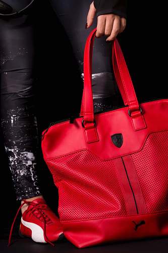 accessory person holding red Puma leather tote bag bag