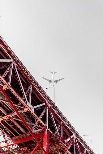 bridge low angle photography of transportation plane above the bridge lisbon