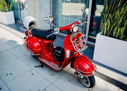 clothing red motor scooter parked near glass door helmet