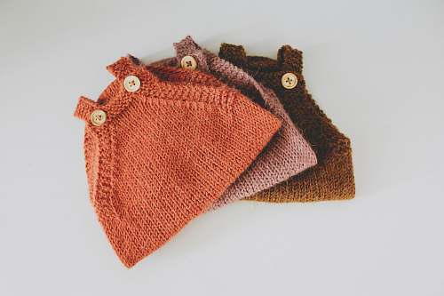 clothing three assorted-color crochet tops near white wall knitting