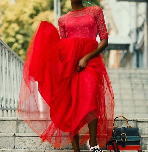 clothing woman standing at staircase while wearing red dress evening dress