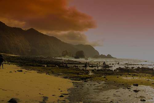 water black mountain near sea under white sky during golden hour mountain