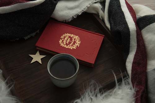 book red hardbound book beside cup of coffee red