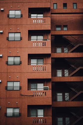 housing brown concrete building with stairs on the side window