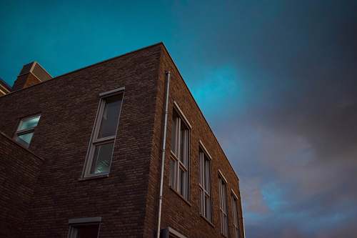 window low angle photography of a brown concrete building brick