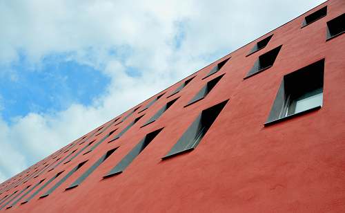 windows low-angle photography of red concrete building perspective