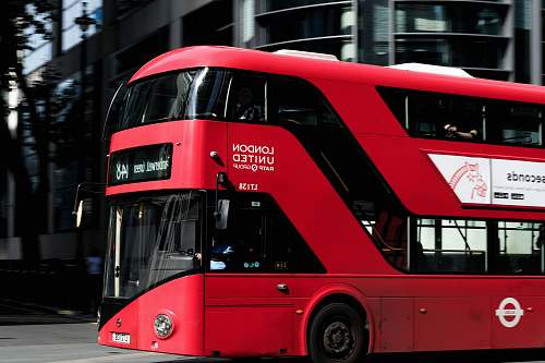 transportation red and black bus near building vehicle