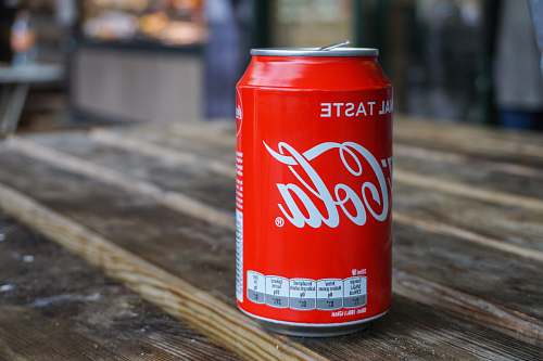 tin Coca-Cola can on brown wooden table drink