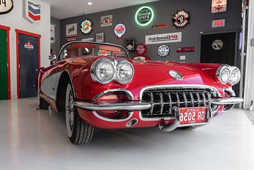 classic red coupe inside gray garage vintage